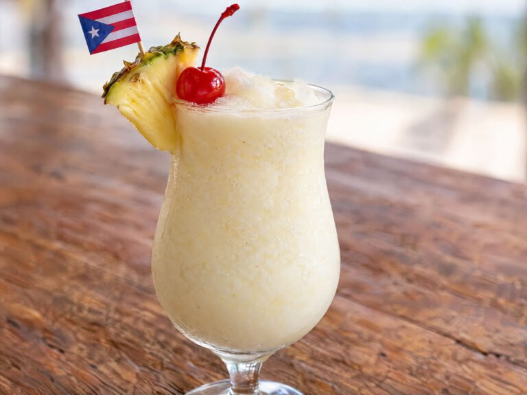 Creamy Puerto Rican Piña Colada with pineapple and coconut in a white cocktail glass