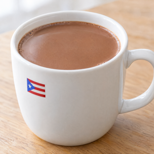 Creamy Puerto Rican hot chocolate in a plain white mug on a natural wooden table